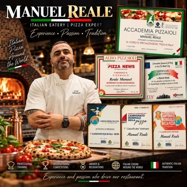 Chef Manuel Reale in chef's whites beside a pizza and his framed pizza championship certificates